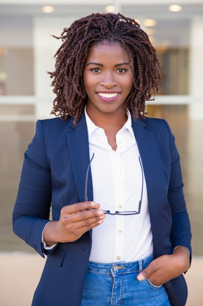 Happy successful sales agent posing near office