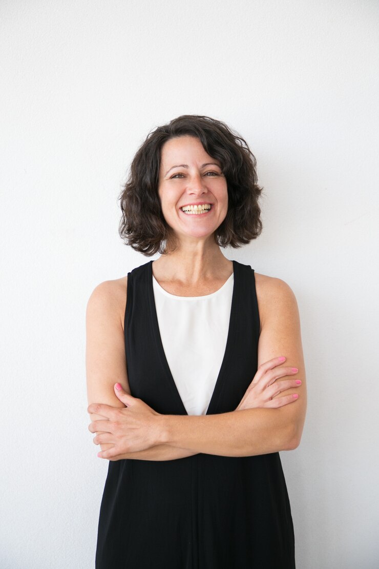 Free Photo happy successful woman posing with folded arms