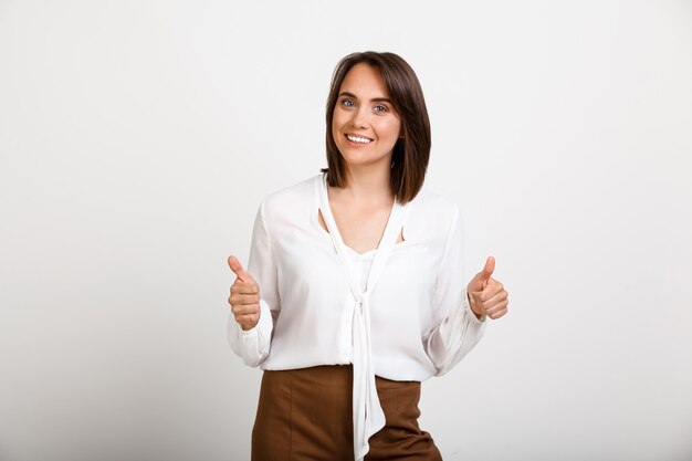 Happy successful woman thumbs-up, give approval