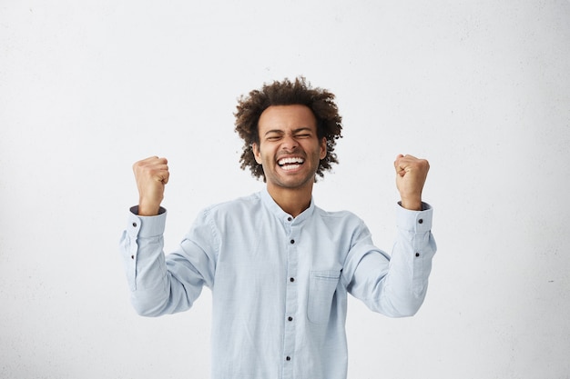 Free photo happy successful young businessman screaming