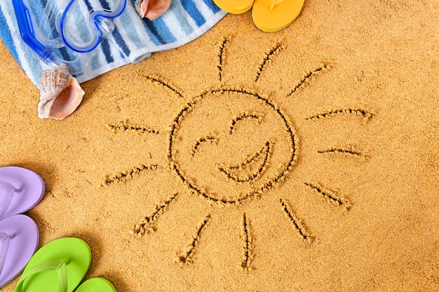 Happy sun drawn in the sand