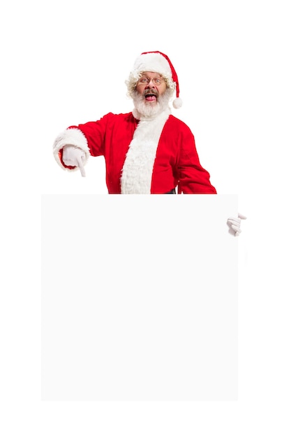 Free photo happy surprised santa claus pointing on blank advertisement