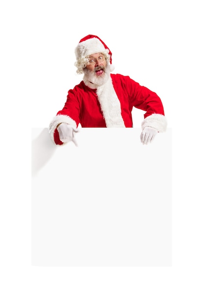 Happy surprised Santa Claus pointing on blank advertisement