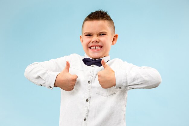 Happy teen boy smiling isolated on blue studio