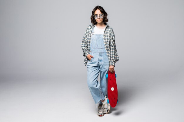 Happy teen girl holding skate board isolated