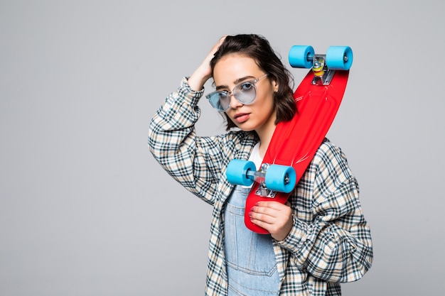 Happy teen girl holding skate board isolated