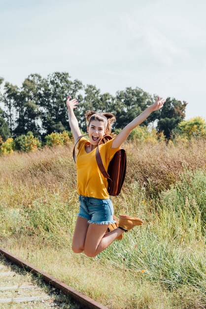 Happy teen girl jumping on the railway