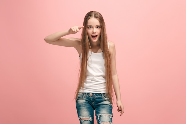 あなたを指している幸せな十代の少女、ピンクの半分の長さのクローズアップの肖像画。