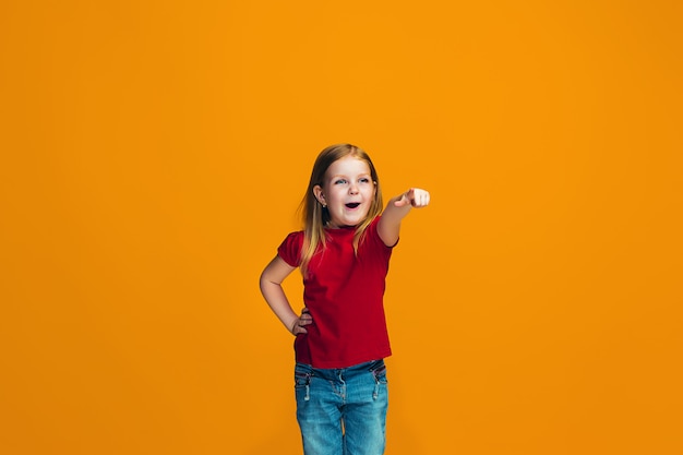 The happy teen girl pointing to you, half length closeup portrait