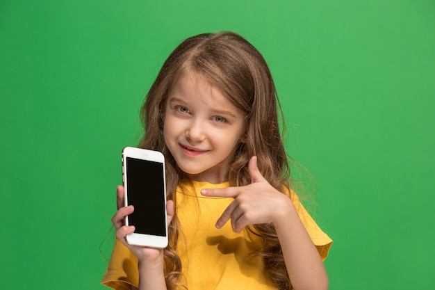 Free photo the happy teen girl standing and smiling against green background.