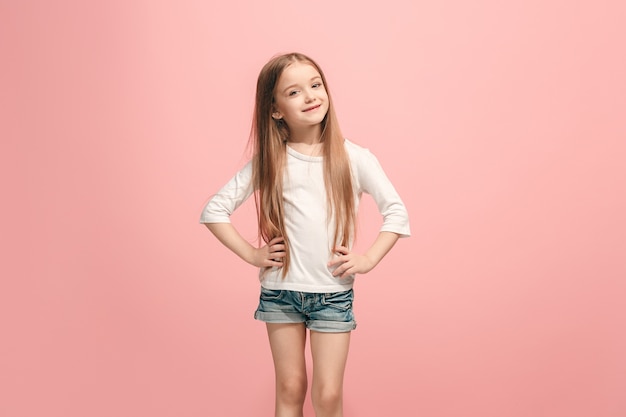 Happy teen girl standing, smiling isolated on trendy pink studio
