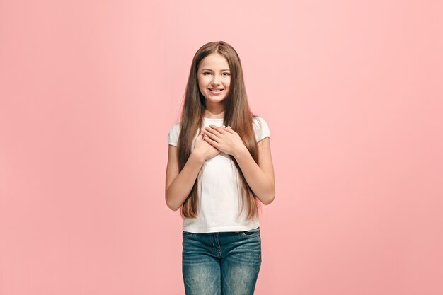 Happy teen girl standing, smiling isolated on trendy pink studio.