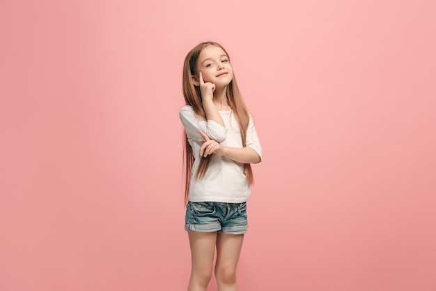 Happy teen girl standing, smiling isolated on trendy pink studio