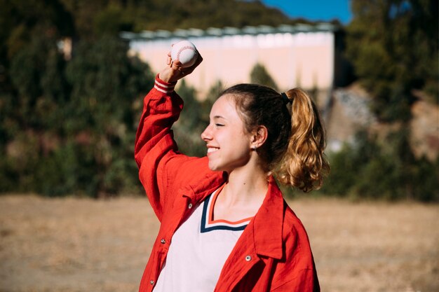 野球のボールで幸せな十代の少女