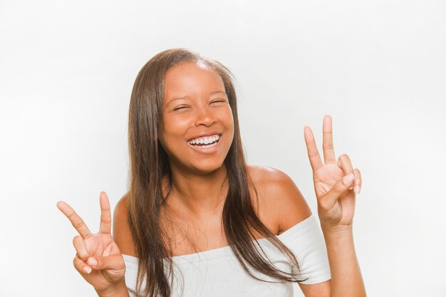 Happy teenage girl gesturing peace sign