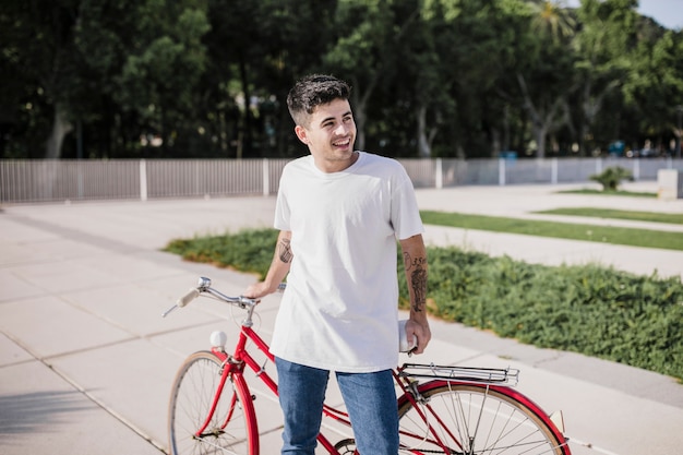 Free photo happy teenager enjoying outdoors with his bicycle