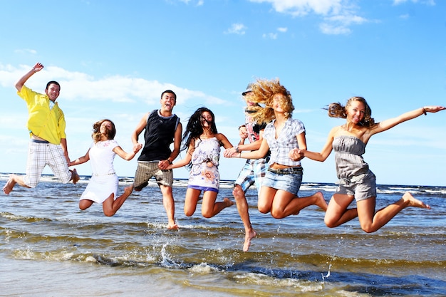 Счастливые подростки играют на море
