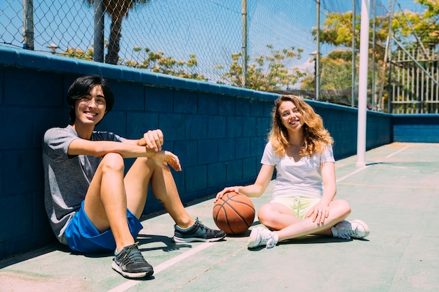농구 피치에 앉아 행복 한 청소년