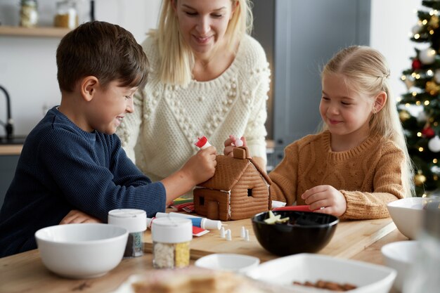 Happy time of family decorating gingerbread house