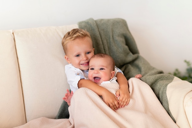Happy toddler hugging adorable sibling