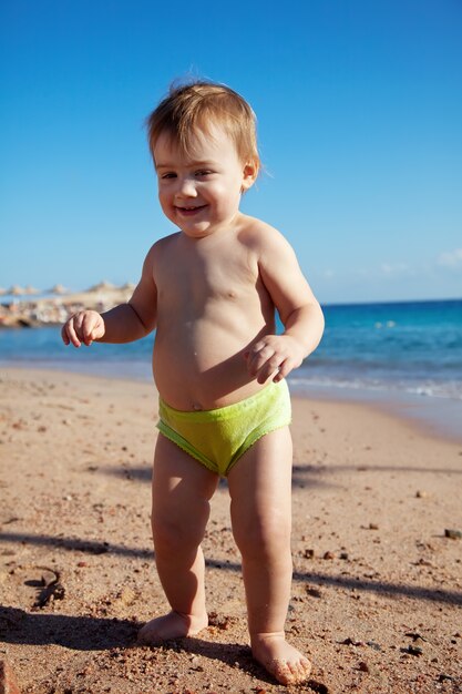 Happy toddler on sand beach