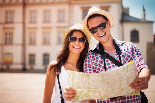 Free photo happy tourists couple holding map