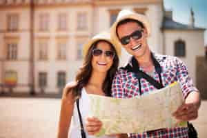 Free photo happy tourists couple holding map