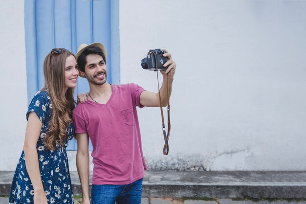 Happy tourists taking selfie with camera