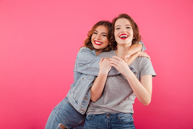 Happy two women friends hugging.