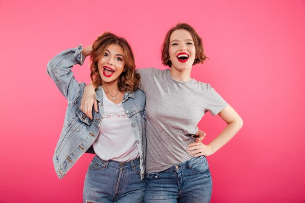 Happy two women friends hugging.