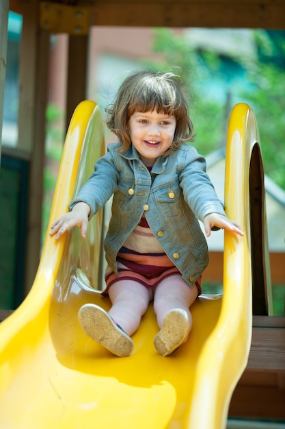 Free photo happy two-year  girl in jacket on slide