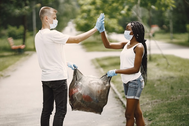 Foto gratuita volontari felici che si danno il cinque l'un l'altro dopo aver completato i compiti. ragazza afroamericana e ragazzo europeo.