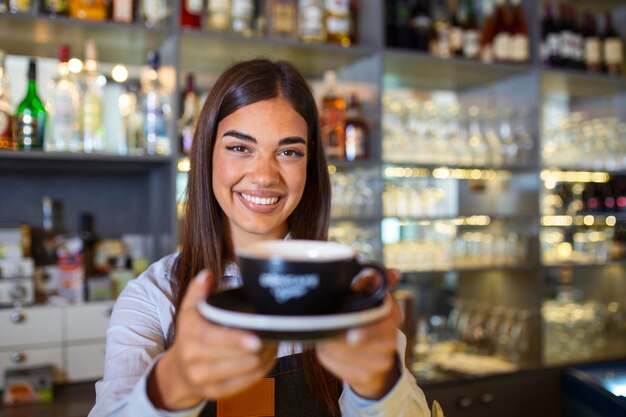 Happy waitress holding tray with cup of coffee working in cafeteria and serves the table