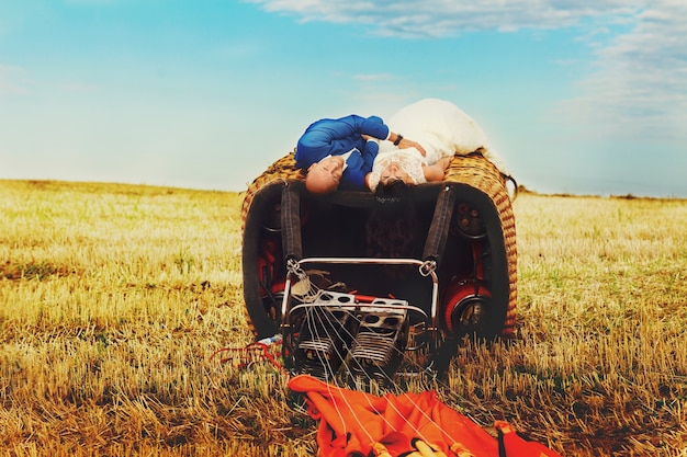 Free photo happy wedding coule lies on the basket of air balloon