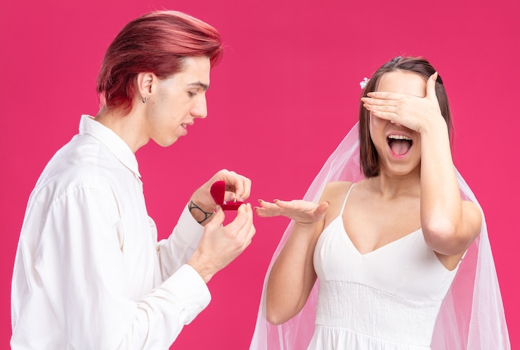 मुफ़्त फोटो happy wedding couple of groom and bride man making propose with wedding ring in a gift box happy and excited