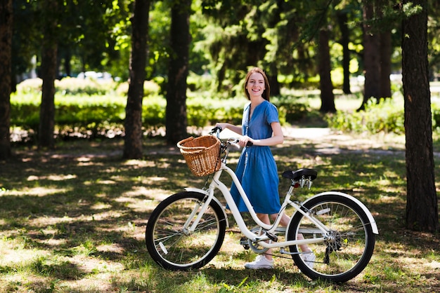 Happy woman alongside bicycle
