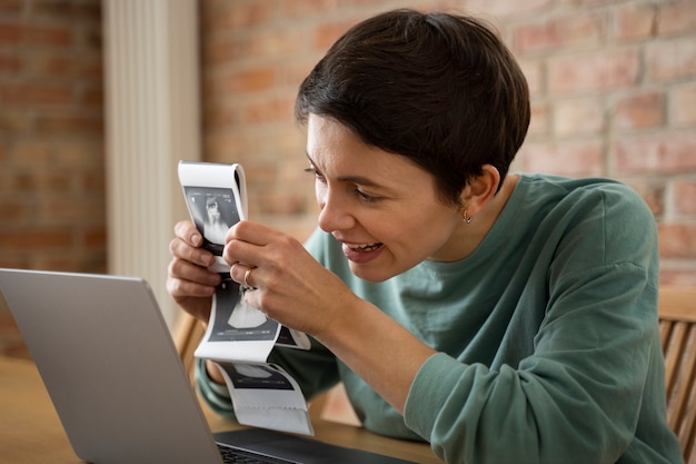 Free photo happy woman announcing pregnancy with ultrasound over videocall