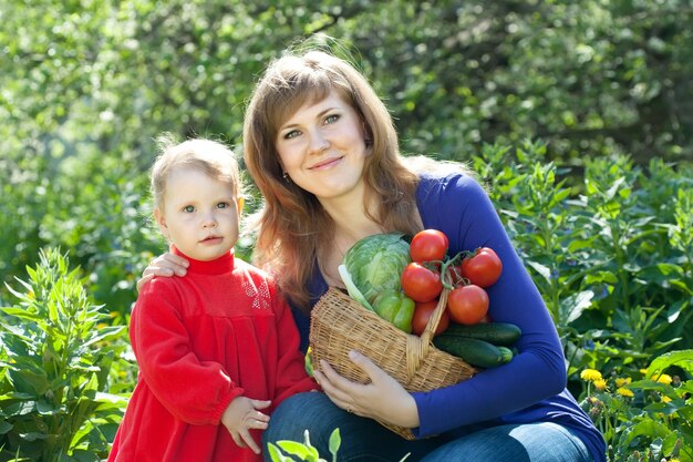 Happy woman and baby girl with vegetables