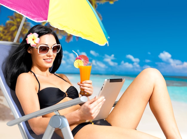 Happy Woman On The Beach With Ipad.