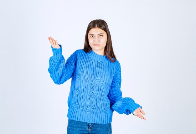 happy woman in blue sweater standing on white.