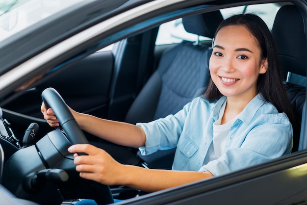 Free photo happy woman in car dealership