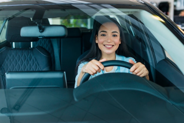 Free photo happy woman in car dealership