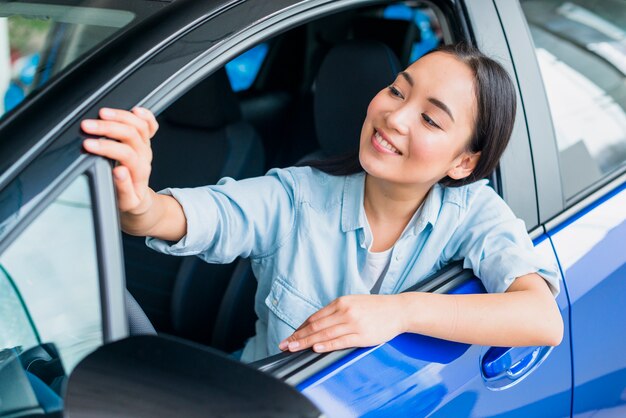 Happy woman in car dealership