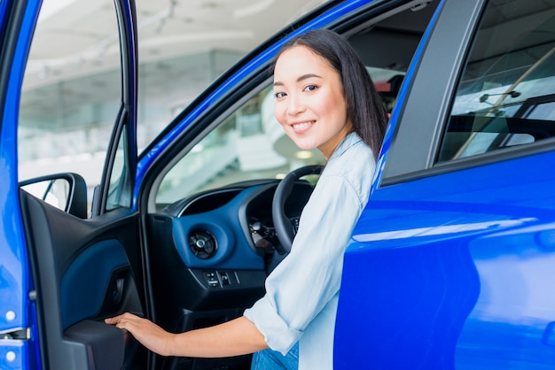 Happy woman in car dealership