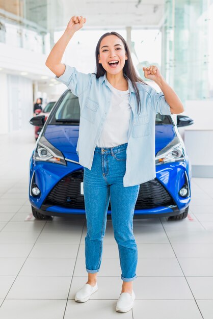 Happy woman in car dealership