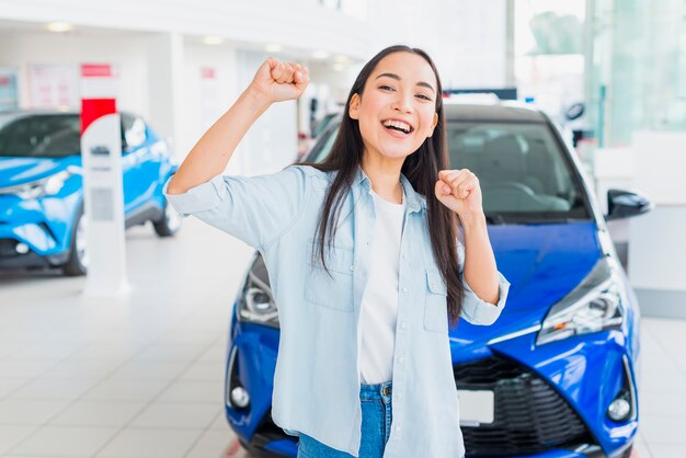 Happy woman in car dealership