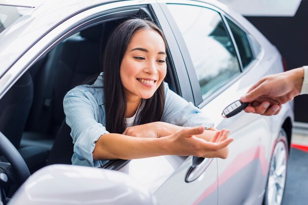 Happy woman in car dealership