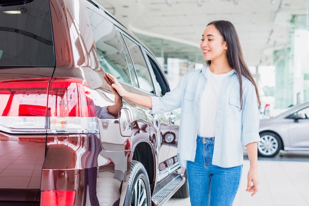 Happy woman in car dealership