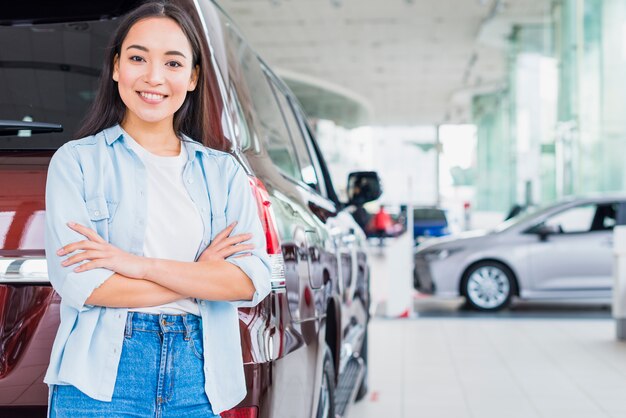 Happy woman in car dealership