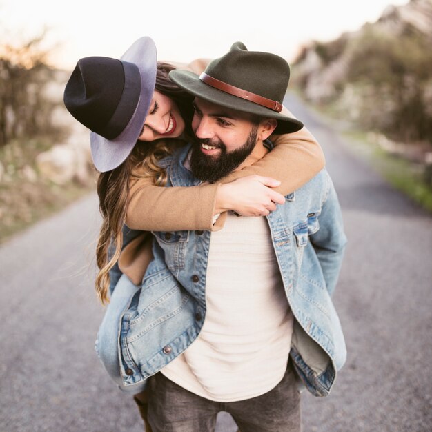 Happy woman carried on boyfriend back